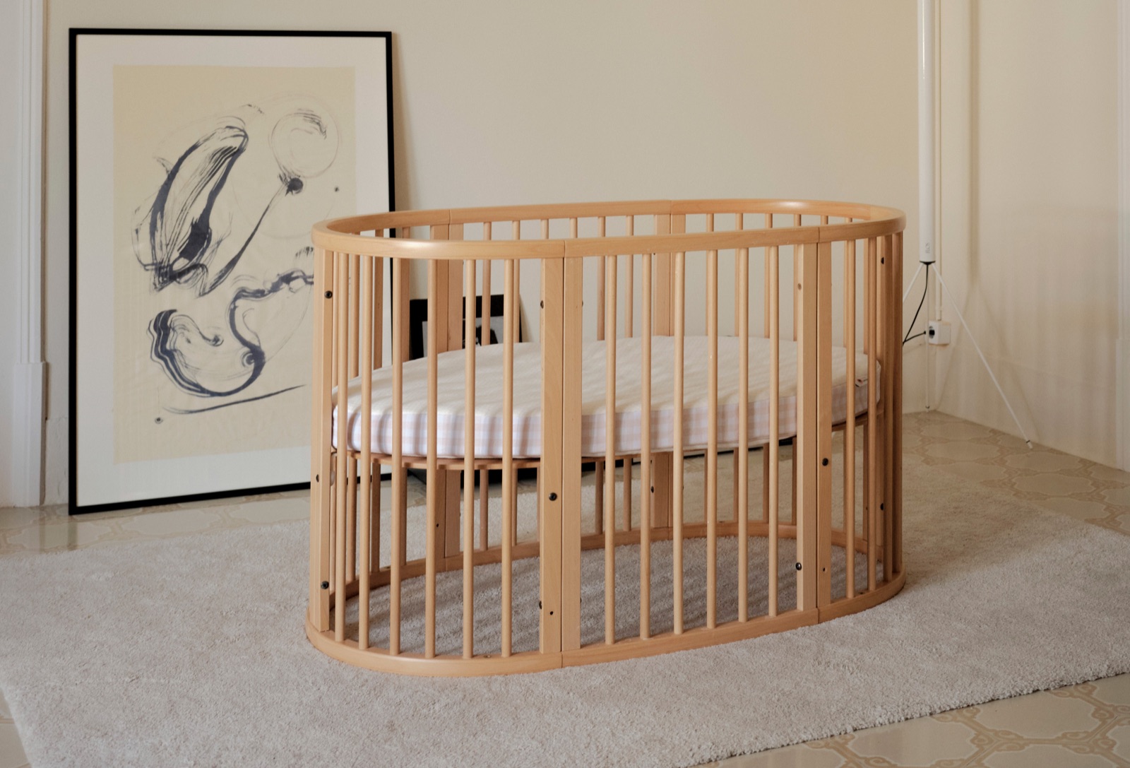 Cuna de madera con el colchón en un dormitorio cálido